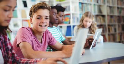 Students using laptop, digital tablet in library