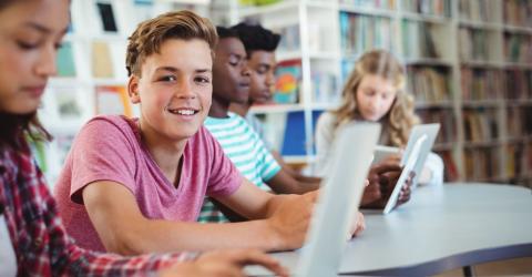 Students using laptop, digital tablet in library